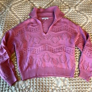 This is a medium pink sweater with collar.
